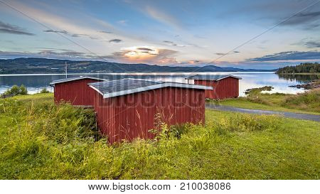 Red Wooden Cabins On Waterfront Of Lake In Norway