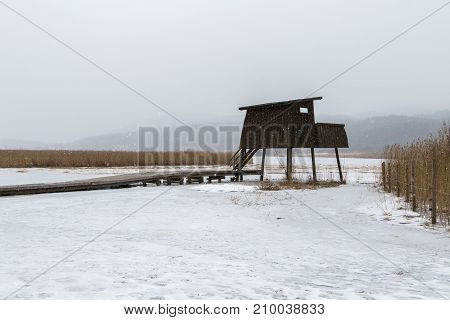 Bird watching tower in Borsesjo, snow in the air and snow and ice coverint the lake and ground. Skien, Norway