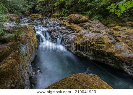 Water Cascading Over Mossy Rocks In Brice Creek