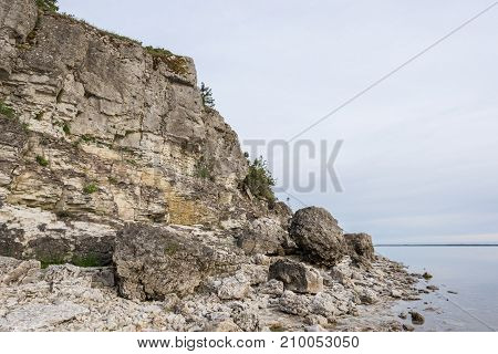 Sunset on the beach. Limestone cliff in the sea under blue sky and white clouds. Kesselaid a small island in Estonia. Nordic countries Europe