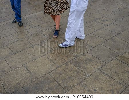 Legs of a couple dancing with 60s shoes.