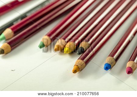 view of a set of oloured pencil over a white table. school.