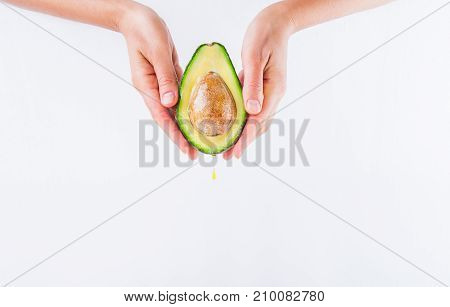 Fresh Avocado With Oil Drop In Female Hands On The White Background Isolated. Healthy, Natural Beaut