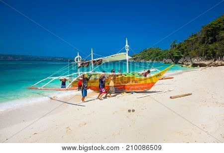 BORACAY, PHILIPPINES-MARCH 21, 2016: Local fishermen take the traditional boat to the shore at Puka beach on March 21, 2016. Boracay island. Philippines.
