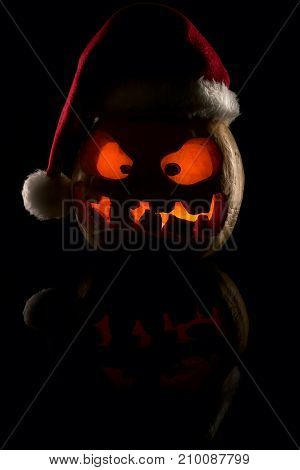 The Concept Of Halloween And The New Year And Christmas. The Evil Scary Pumpkin Santa In The Santa C