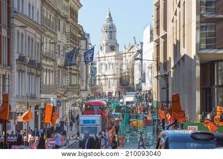 London, UK - March 15, 2017: Busy City of London street with lots of traffic and walking people and St. Paul's cathedral at the background