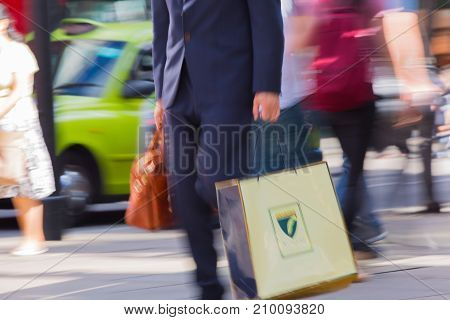 LONDON, UK - June 9, 2017: Blurred image of walking man with shopping bag at Oxford street, the main destination for shopping at Westend.