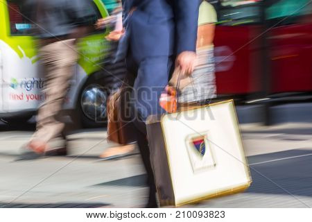 LONDON, UK - June 9, 2017: Blurred image of walking man with shopping bag at Oxford street, the main destination for shopping at Westend.