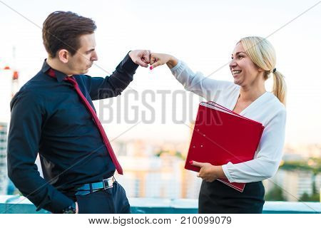 Couple Of Businessmen, Young Brunette Man And Young Beauty Blonde Woman Stand On The Roof With Paper