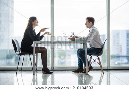 Businessman And Businesswoman Meeting In Modern Office Face To Face Discuss Plans