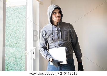 Male Robber Stealing A Computer
