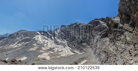 From below panoramic view of man climbing high on mountain