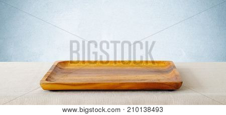 Empty squre wooden tray on sack tablecloth background banner food display montage food background