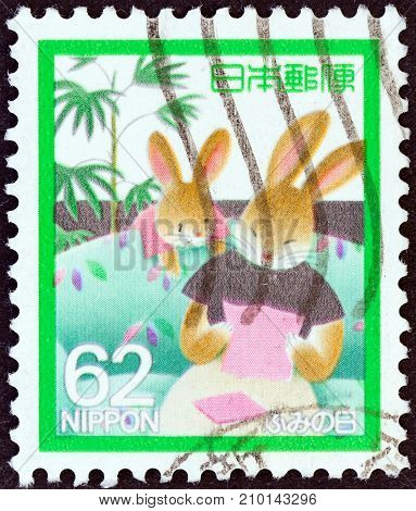 JAPAN - CIRCA 1989: A stamp printed in Japan issued for the letter writing day shows Mother Rabbit reading letter, circa 1989.