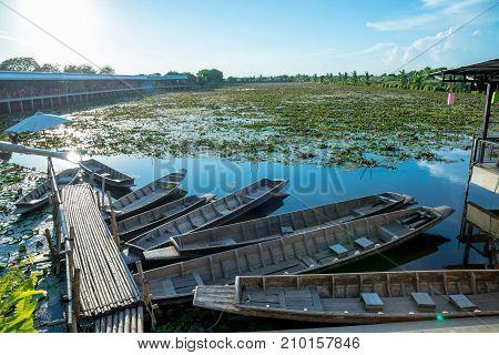 Lotus marsh and wood boat with sky background at Banglane Nakorn pathum Thailand.