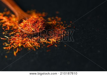 Dried Saffron Spice On Black Background. Raw Organic Pistil Powder Saffron Are Scattered On The Tabl