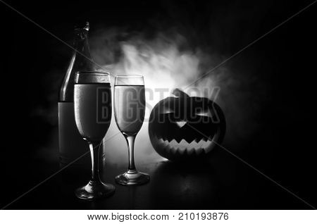 Two Glasses Of Wine And Bottle With Halloween - Old Jack-o-lantern On Dark Toned Foggy Background. S