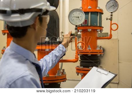 Engineer checking Condenser Water pump and pressure gauge chiller water pump with pressure gauge.