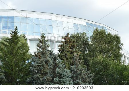 Modern Office Building Of Glass On Background Of Trees