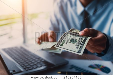 Businessman with money in hand US dollarinvestment success and profitable business concepts.