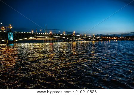 Bridge in Saint-Petersburg with lights illumination in summer white night, Neva river, toned