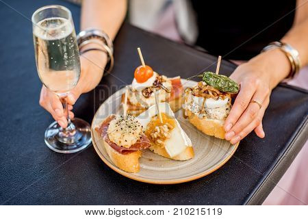 Beautiful and colorful set of pinchos, traditional spanish snack related to tapas, with glass of wine outdoors on the table