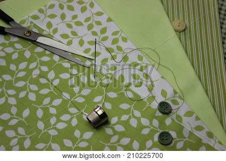Multicolored cuts of fabric with coils of thread on the background of boards