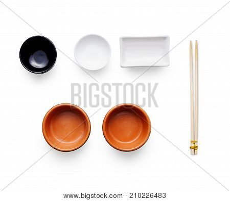 Pieces of traditional japanese tablewear. Small bowls and bamboo chopsticks isolated at white background. Top view, flat lay, copy space, white background