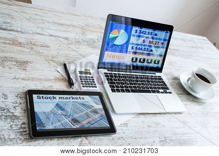 Stock market calculations with a calculator and research software on a Tablet PC with a Laptop computer.