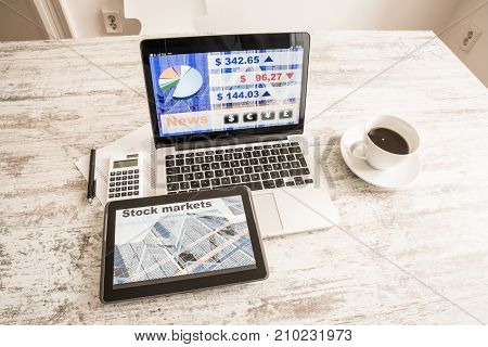 Stock market calculations with a calculator and research software on a Tablet PC with a Laptop computer.