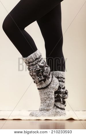 Winter fashion. Woman legs wearing fashionable wintertime clothes woolen warm socks and black tights