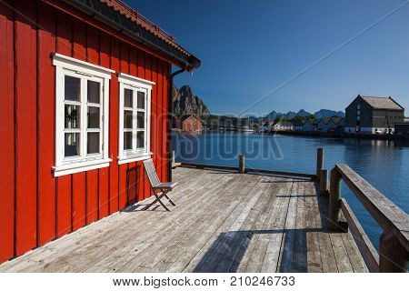 Henningsvaer Norway - August 192017: Picturesque fishing port in Henningsvaer on Lofoten islands Norway with typical red wooden buildings and small fishing boats
