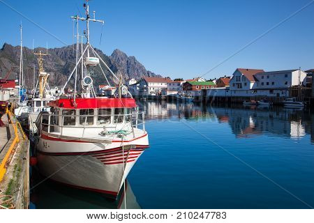 Henningsvaer Norway - August 19 2017: Picturesque fishing port in Henningsvaer on Lofoten islands Norway with typical red wooden buildings and small fishing boats