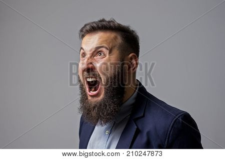 Concept of anger. Bearded man in suit shouts in a state of anger. Black and white image in vintage style.