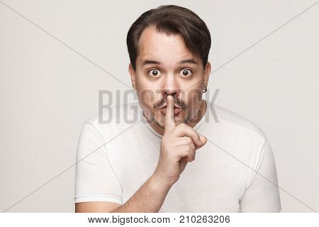 Shh Sign. Man With Big Eyes Looking At Camera With Silent Sign.