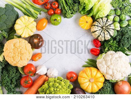 Colorful vegetables arranged in a circle on the light grey background, copy space for text in the middle, selective focus