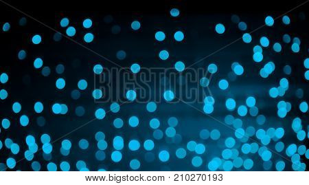 Beautiful Festive Christmas abstract Background with bokeh lights. Holiday Wide screen Wallpaper. Blue light spots on black background defocused. Decorative pattern of scatter lights