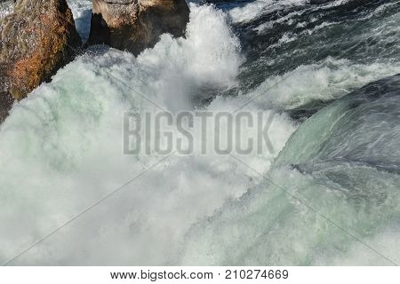 Partial view of the Rhine Falls waterfall in Switzerland seen from the Laufen castle. The Rhine Falls is the largest waterfall in Europe located on the border between the Swiss cantons of Zurich and Schaffhausen.