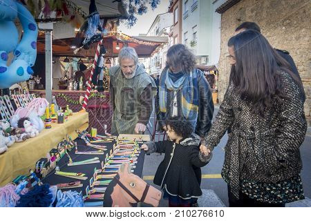 OLIVA, VALENCIA, SPAIN, 15TH JANUARY 2017 - A young child playing with hand made wooden toys on a Medieval market stall in Oliva Valencia Spain