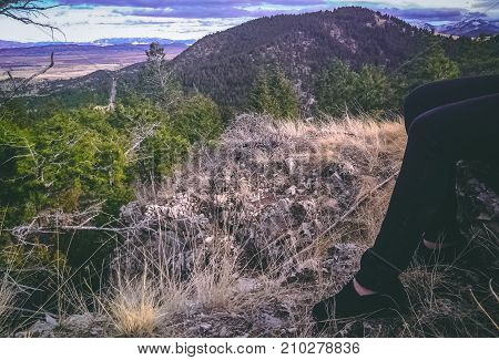 Woman's legs and feet with hills as backdrop