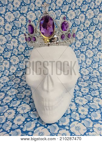 Styrofoam skull with a princess crown against flowers background