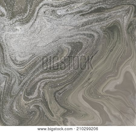 Liquid gold marbled pattern. Pale beige background. Golden powder