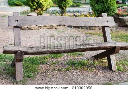 View of stylish wooden brown beanch in park. Garden furniture for family and company