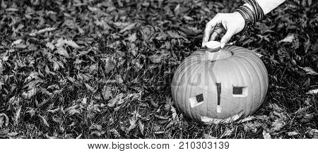 Closeup On Woman Putting Candle In Pumpkin Jack O’lantern