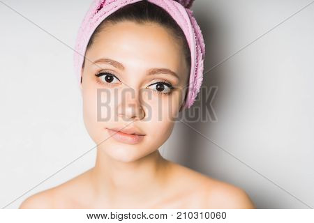 girl after shower with a pink towel on her head cute looks at the camera, isolated on a white background