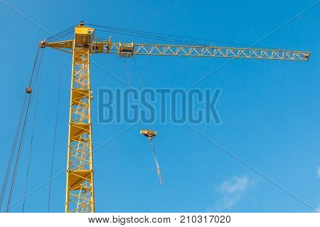Construction Tower Crane Against The Background Of The Blue Sky Skyline