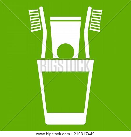 Plastic cup with brushes icon white isolated on green background. Vector illustration