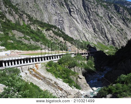 Scenic stony road tunnel in swiss Alps in SWITZERLAND near Andermatt town with alpine rocky mountains range landscape scenery in 2017 warm sunny summer day Europe on July.