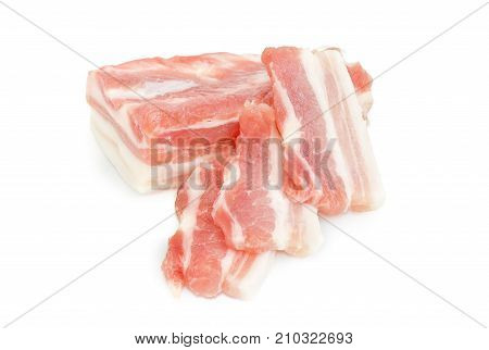 Partly sliced uncooked streaky pork belly on a white background