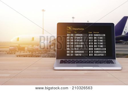 Technology for comfortable travel tourist traveler concept : Flight status on notebook laptop with airport and blur airplane background film effect. Check in online. Check flight status online.